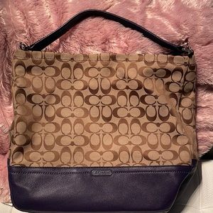 Coach signature bag with purple leathered traps and purple leather bottom .
